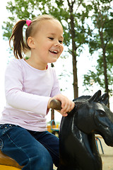 Image showing Cute little girl is swinging on see-saw