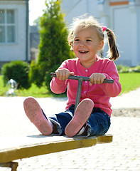 Image showing Cute little girl is swinging on see-saw