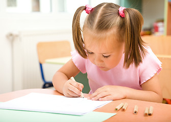 Image showing Little girl is drawing with color pencils