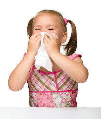 Image showing Little girl blows her nose