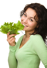 Image showing Beautiful young girl with green lettuce leaf