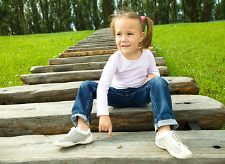 Image showing Cute little girl is sitting on stairs