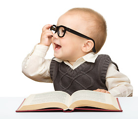 Image showing Little child play with book and glasses