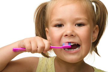 Image showing Little girl is cleaning teeth using toothbrush