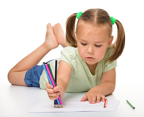 Image showing Little girl is drawing while laying on the floor