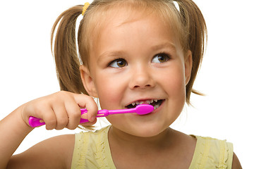 Image showing Little girl is cleaning teeth using toothbrush