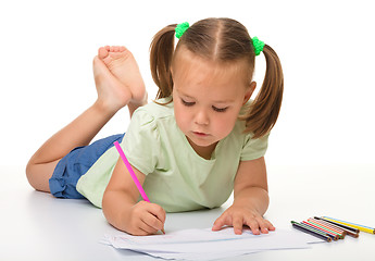 Image showing Little girl is drawing while laying on the floor