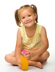 Image showing Little girl drinks orange juice