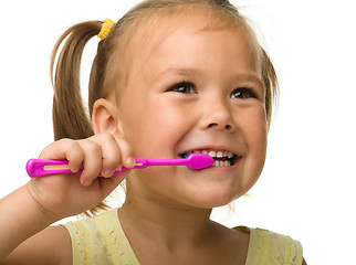 Image showing Little girl is cleaning teeth using toothbrush