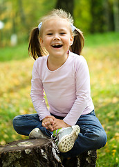 Image showing Little girl is playing in autumn park