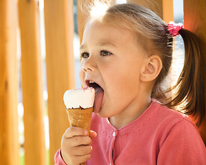 Image showing Little girl is eating ice-cream