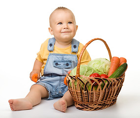 Image showing Cute little boy with basket full of vegetables