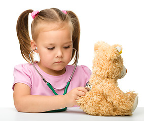 Image showing Little girl is playing with her teddy bear