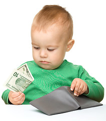 Image showing Cute little boy is counting money