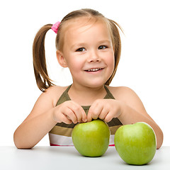 Image showing Little girl with two green apples