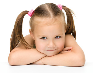 Image showing Cute little girl is sitting at the table