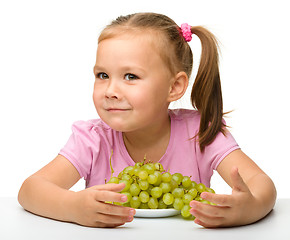 Image showing Little girl is eating grapes