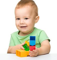 Image showing Little boy plays with building bricks