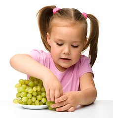 Image showing Little girl is eating grapes