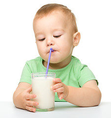 Image showing Cute little boy is drinking milk