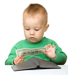 Image showing Cute little boy is counting money