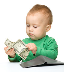 Image showing Cute little boy is counting money