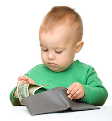 Image showing Cute little boy is counting money