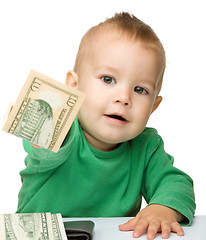 Image showing Cute little boy is counting money