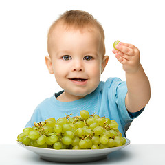 Image showing Little boy is eating grapes