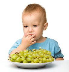 Image showing Little boy is eating grapes