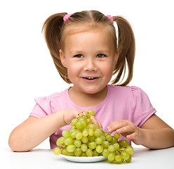 Image showing Little girl is eating grapes