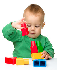 Image showing Little boy plays with building bricks