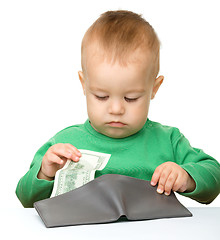 Image showing Cute little boy is counting money