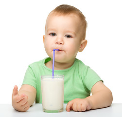 Image showing Cute little boy is drinking milk