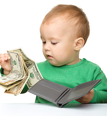 Image showing Cute little boy is counting money