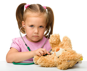 Image showing Little girl is playing with her teddy bear