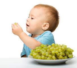 Image showing Little boy is eating grapes