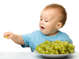 Image showing Little boy is eating grapes