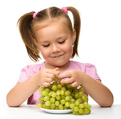 Image showing Little girl is eating grapes