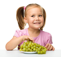 Image showing Little girl is eating grapes