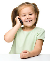 Image showing Cute little girl is talking on cell phone