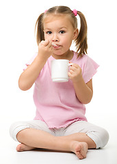 Image showing Cute little girl is eating