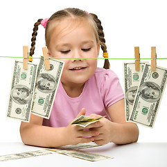 Image showing Cute little girl with paper money - dollars