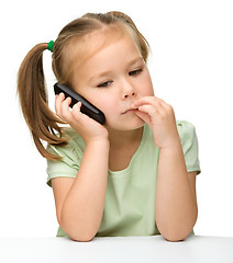 Image showing Cute little girl is talking on a cell phone