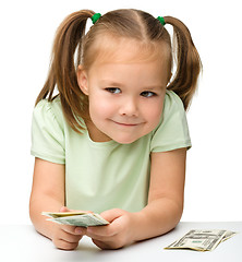 Image showing Cute little girl with paper money - dollars