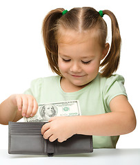 Image showing Cute little girl plays with money