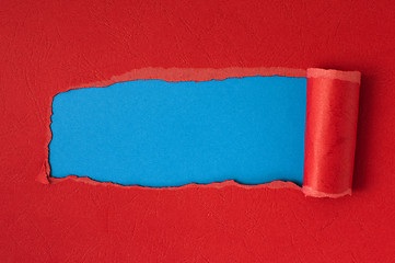 Image showing Red torn paper with blue space for text 