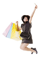 Image showing Jumping Chinese woman holding shopping bags and credit card.