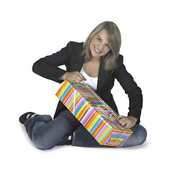 Image showing sitting girl unwrapping a present