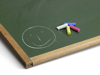 Image showing blackboard with smiley and crayons